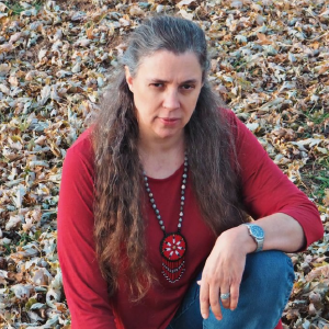 gray hair middle aged woman kneeling with medallion 